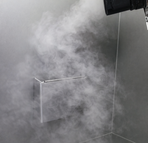 Airflow visualization showing turbulent smoke patterns and lateral airflow movement within a hood work area